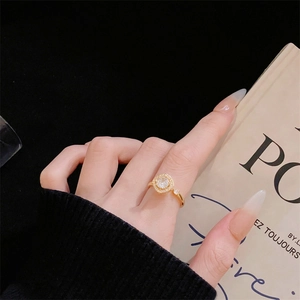 Nahaufnahme der goldenen rotierenden Halo-Ring mit funkelnden Diamanten am Finger