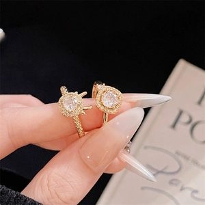 Detailaufnahme von zwei vergoldeten Halo-Ringen mit funkelnden Kristallen an der Hand