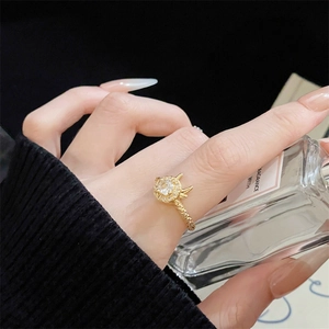 Detailaufnahme von goldener drehbarer Ring mit Kronenmuster und funkelnden Steinen