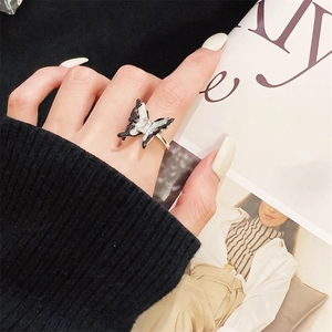 Detail of a black and white butterfly open ring with silver metal and zircon on finger