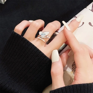 Detail of silver butterfly ring with mother-of-pearl wings and small pearls on hand
