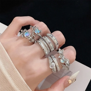 Silver stacked ring set featuring butterfly, star motifs and moonstone inlays on model hand