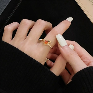 Detail van vintage gouden ring met rode zirkoon en groene bladaccenten