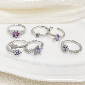 Set de anillos plateados con cristales de circón púrpura y motivos de flores y estrellas
