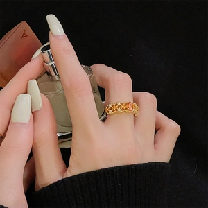 Close-up van een vintage gouden kanten ring met oranje zirkoon aan een vrouwenvinger