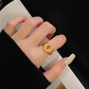 Detailopname van vintage goud geborstelde ring met rode edelsteen en zirkoon