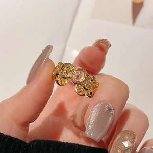 Nahaufnahme eines goldenen Vintage-Rings mit hohlem Blumendesign und ovalem Edelstein