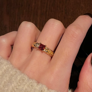 French vintage gold ring with red gemstone and leaf relief carving on finger