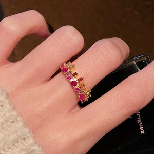 Detail of colorful gemstone ring with gold finish and mixed-cut zircons on hand