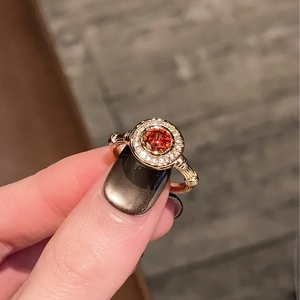 Detailed macro view of an orange gemstone ring with bamboo design and pave setting