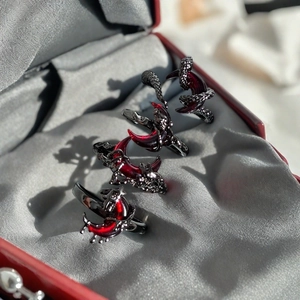 Macro detail of three gothic dark red moon rings in a red jewelry gift box