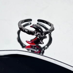 Macro shot of dark gothic crescent moon ring with red gradient and textured black metal
