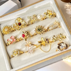 Set de anillos vintage dorados de flores con perlas y gemas en caja de terciopelo