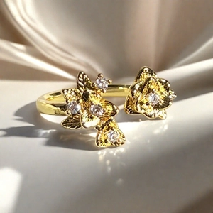 Detalle macro de anillo de flor dorada con pétalos tallados y circonita brillante