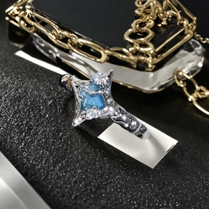 Vue rapprochée d'une bague argentée avec pierre bleue carrée et détails en micro-pavé