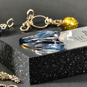 Vue détaillée d'une bague papillon bleue avec une texture de métal liquide irrégulière