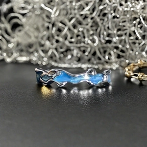 Vue détaillée de la bague argentée irrégulière avec émail bleu translucide poli
