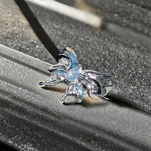 Détail de la bague papillon bleue avec texture plissée irrégulière et lustre en métal argenté