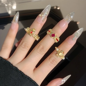Vintage-Ring in Gold mit rotem Zirkon und Emaille an Hand mit luxuriöser Nagelkunst