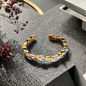 Detailansicht eines Goldrings mit Emaille in Pink und Blau und funkelnden Zirkonia