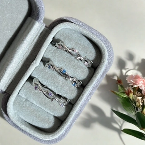 Détails des bagues épines avec zircons roses, bleus et violets dans un écrin à bijoux