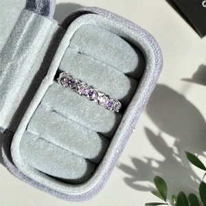Détail de la bague croisée argentée avec zircons roses et violets en boîte