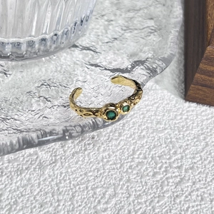 Verstelbare gouden ring met onregelmatige textuur en twee groene zirkoonstenen voor dames