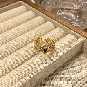 Gedetailleerde macro-opname van vergulde vintage ring met donkerblauwe emaille steen