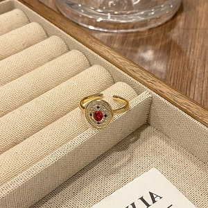 Macrodetail van vintage gouden open ring met rode middensteen en emaille details