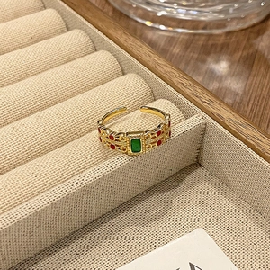 Detail van vintage gouden open ring met groene edelsteen en holle gravures