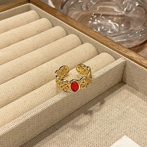 Macro-opname van een vintage gouden ring met bloemig snijwerk en een rode edelsteen
