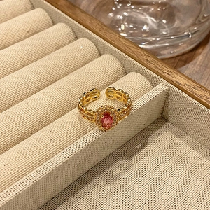 Gedetailleerde macro-opname van vintage gouden ring met roze steen en holle ketting