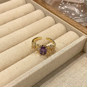 Detailopname van vintage emaille ring met paarse zirkoon in een beige sieradendoosje
