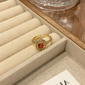 Detail van een vintage gouden ring met oranje steen in een luxe juwelendoosje