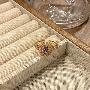 Detailopname van een vintage verstelbare ring met paarse edelsteen en gouden laag