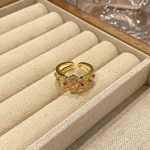 Detail van goudvergulde open ring met roze ovale steen en vintage filigraanpatroon