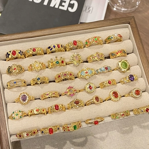 Vintage vergulde ringen set met kleurrijke edelstenen in een houten sieradenlade