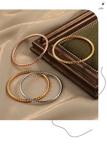Detailaufnahme von dreifarbigen Titanstahl Armreifen mit elegantem Rautenmuster