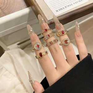 Vintage gouden ringenset met rode edelstenen en gegraveerde details op de hand van een model