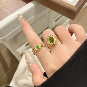 Detailopname van vintage emaille ringen met opengewerkt design en groene steen om