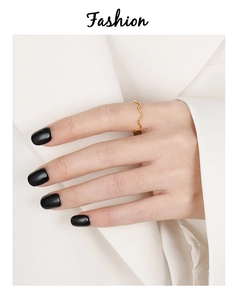 Detailopname van een minimalistische gouden golfring aan de vinger met een witte blazer