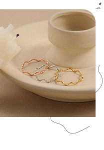 Detail van stapelbare golfringen in roségoud, zilver en goudkleurige afwerkingen