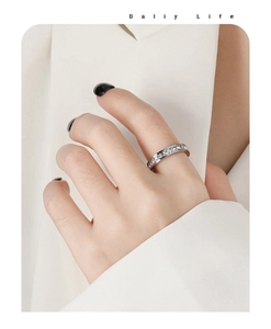 Detailed view of a slender silver band ring with sparkling cubic zirconia channel setting