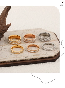 Close-up of gold and silver plated eternity rings with zircon stones on stone background