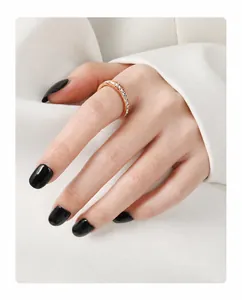 Detail of gold plated eternity ring with sparkling crystals on hand with black nails