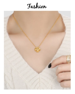 Gros plan détaillé d'un collier pendentif trèfle doré sur un modèle en tricot blanc