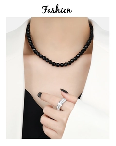 Detail of a black agate beaded necklace and sparkling pave set rhinestone ring set