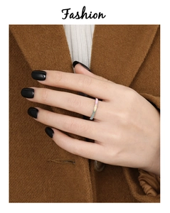 Detail van een minimalistische vergulde ring met witte parelmoer inleg op de vinger
