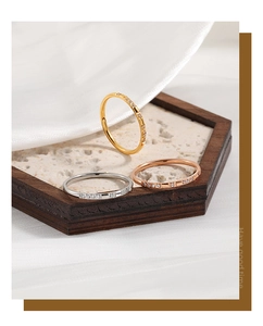 Detailed view of minimalist gold, silver, and rose gold rings with micro-diamonds on silk