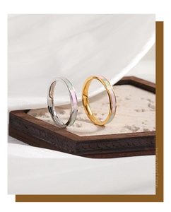 Detailopname van minimalistische gouden en zilveren ringen met iriserende parelmoer inleg